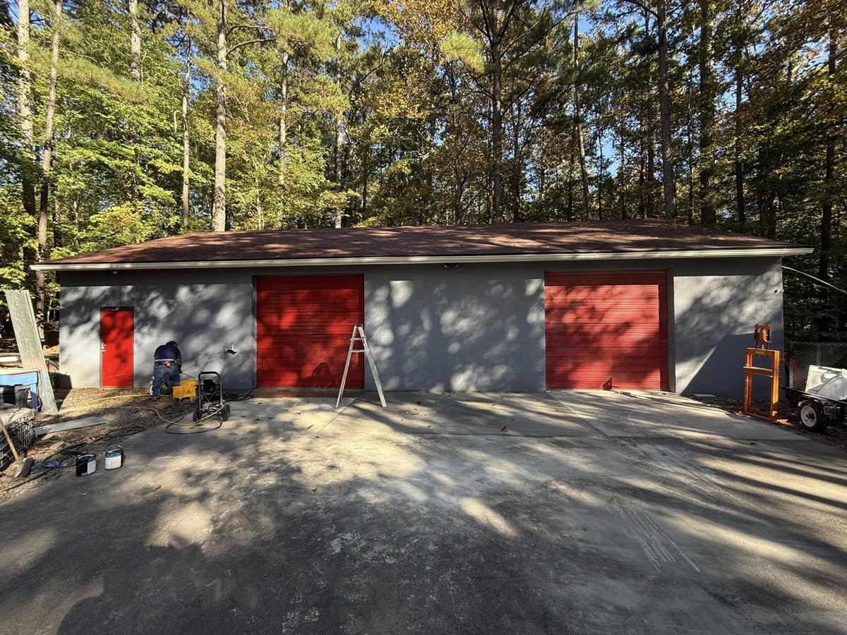 Shop building with new paint and red roll-up doors