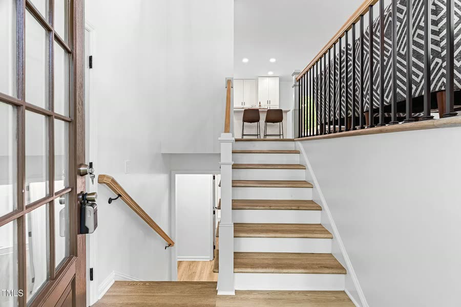 Entry staircase with new flooring and black metal railing