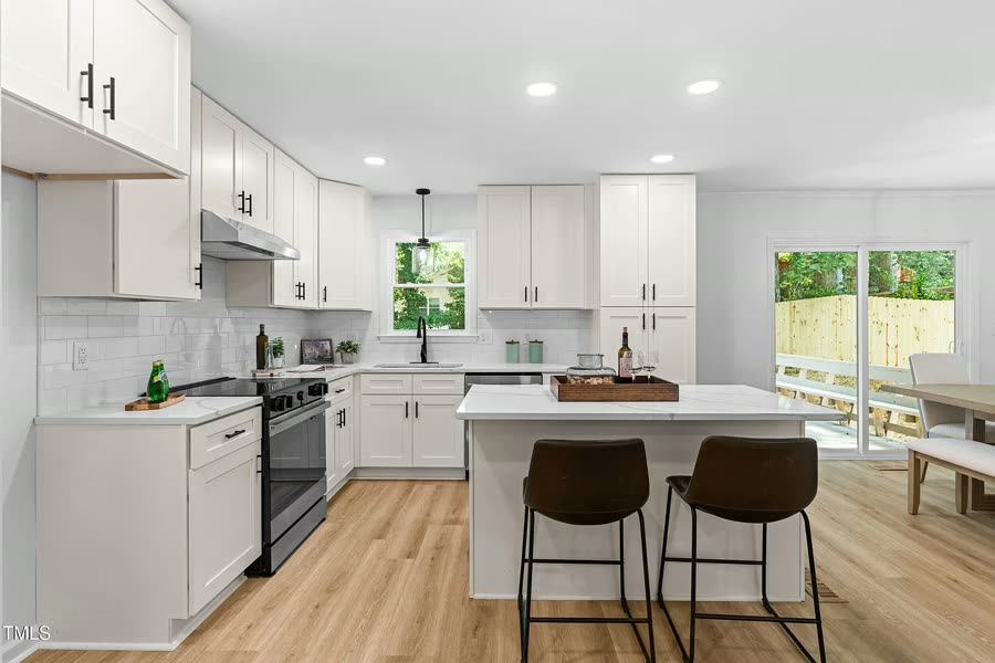 Renovated kitchen with island and pendant lights at the Pickwick project in Raleigh